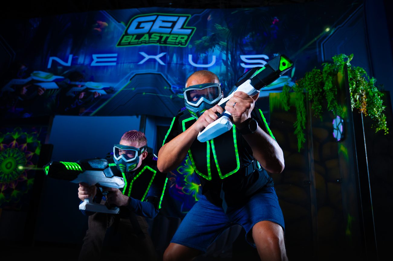 Two players in glowing Nexus Gel Blaster gear inside the arena